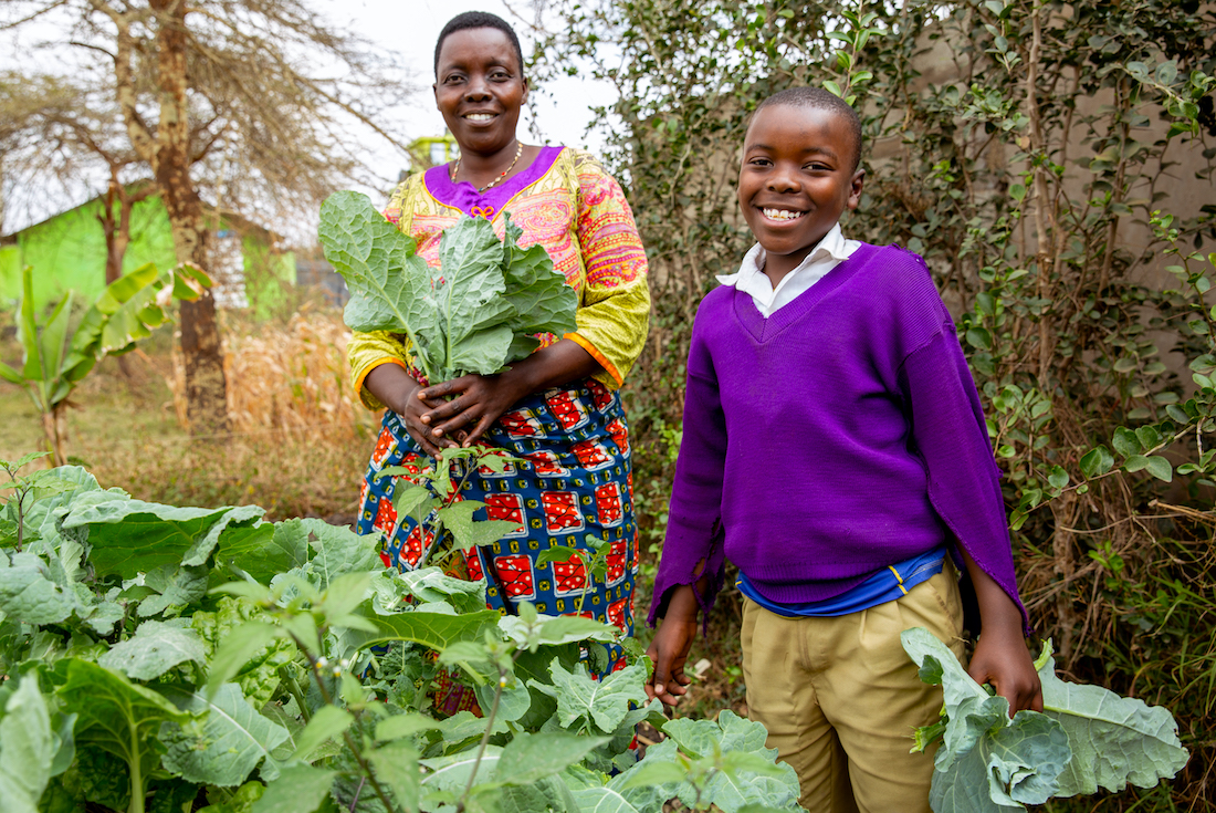 A mother and child harvest and tend to their garden