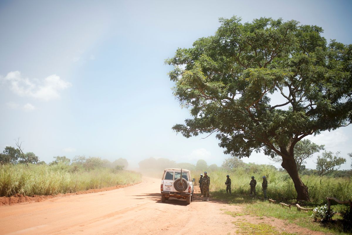 A UN patrol of the Multidimensional Integrated Stabilisation Mission in the Central African Republic wait under a tree for the arrival of the convoy they will escort along the only supply road to the capital in 2017 | FLORENT VERGNES/AFP/Getty Images