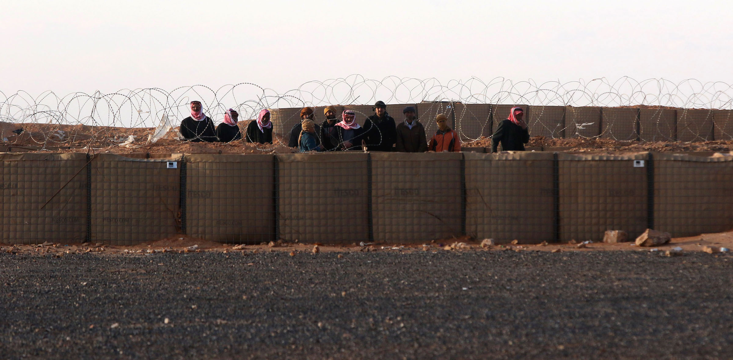 In 2017, Syrian refugees in the no-man's zone between Syria and Jordan are permitted by Jordanian soldiers to seek medical attention. | JORDAN PIX/Getty Images
