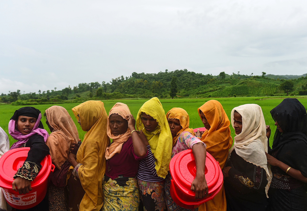 Rohingya Muslim refugees wait in line for relief supplies after fleeing burning villages, the army and ethnic Rakhine mobs
