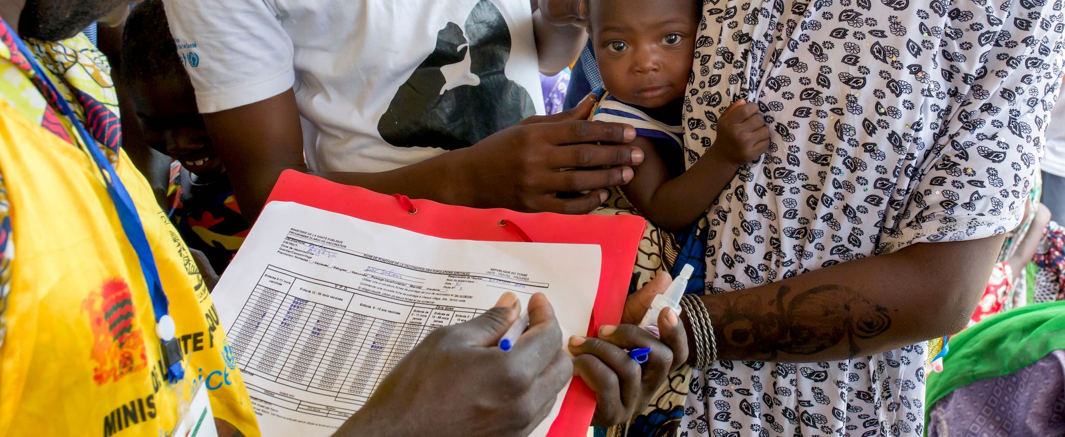 Person holds baby while person is checking their records