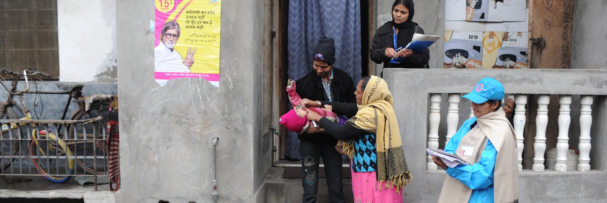 A health worker gives polio drops to a child outside his residence in New Dehli