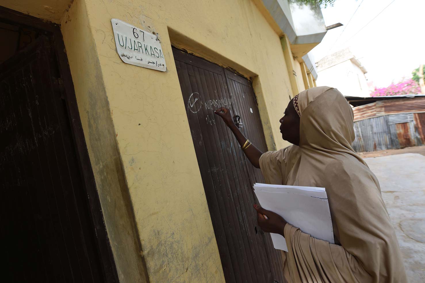 A health worker marks the gate of a house which was visited during a vaccination campaign against polio at Hotoro-Kudu