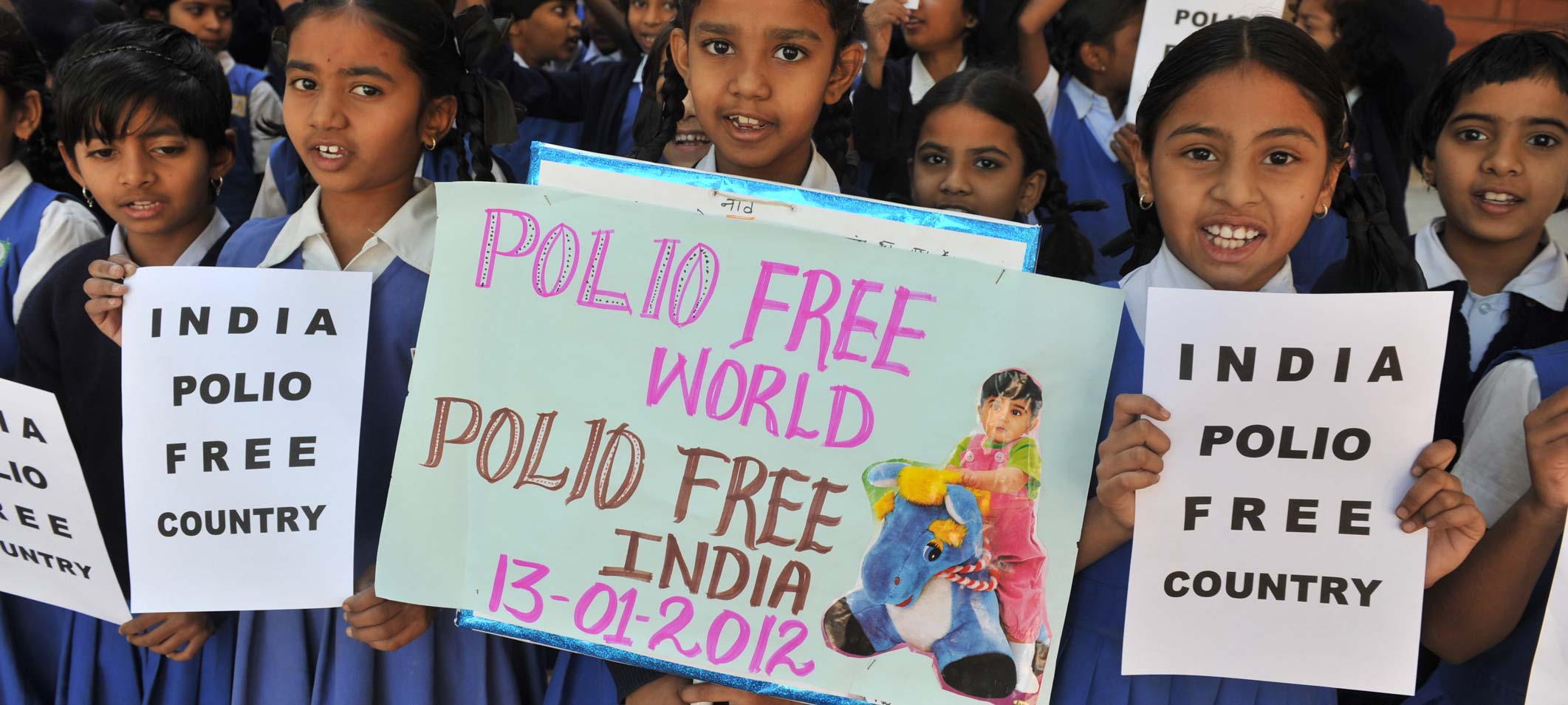 Indian school children hold placards reading 'India Polo Free' during their awareness campaign