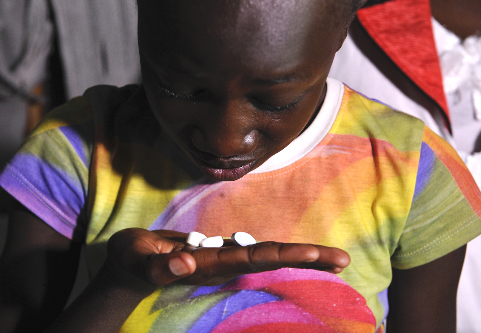 A 13-year-old girl living with HIV takes her drugs at her grandmother's house in Ndiwa in Homa Bay County. | SIMON MAINA/AFP via Getty Images
