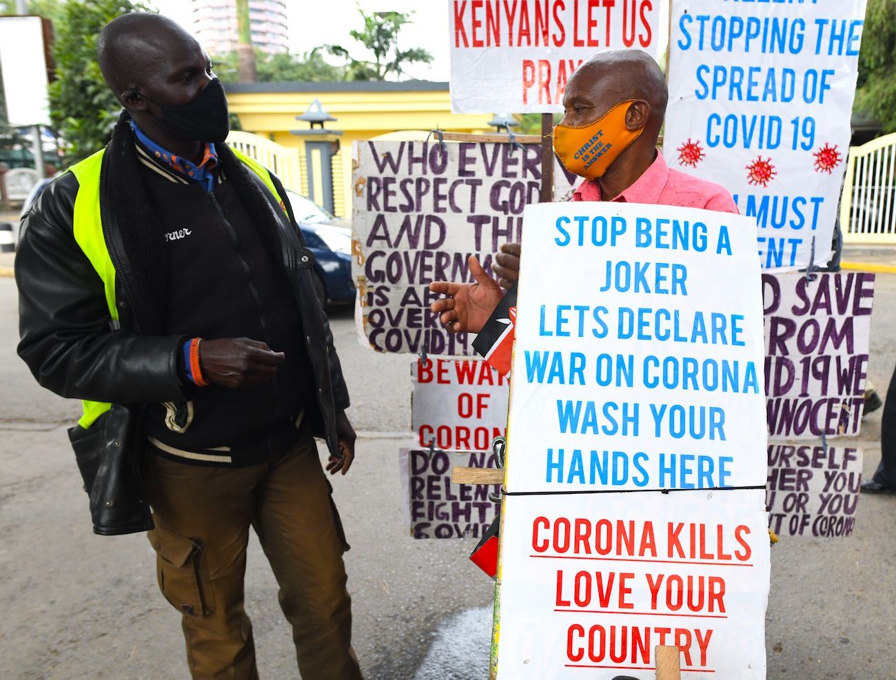 Samson Waithaka, (C) chats with a man by the road side as he rides his bicycle.