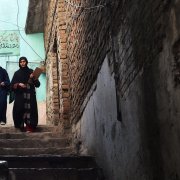 Two Pakistani health workers arrive at a house to vaccinate children