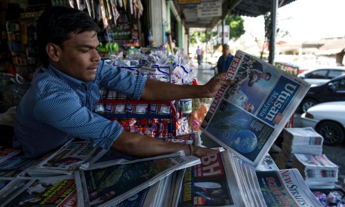 A newspaper seller in Southeast Asia