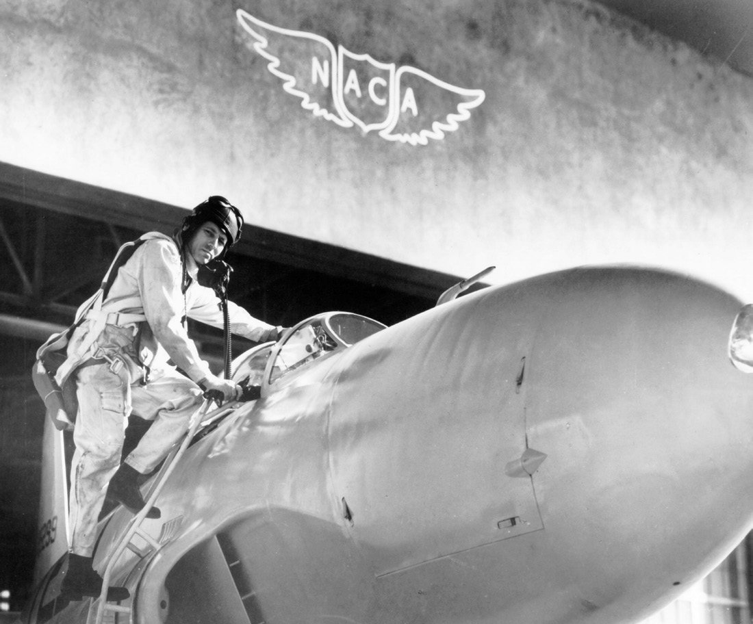 Test pilot Lawrence Clousing boards a Lockheed P-80 aircraft for a test flight at the NASA Ames Research center in Mountain View, California, with a NACA logo visible in the background, 1960. Image courtesy NASA. Photo: Smith Collection/Gado/Getty Images.