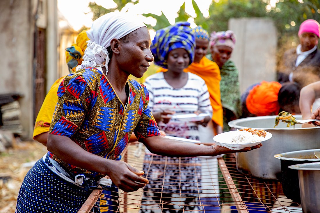 A woman hand out food at a cooking demonstration