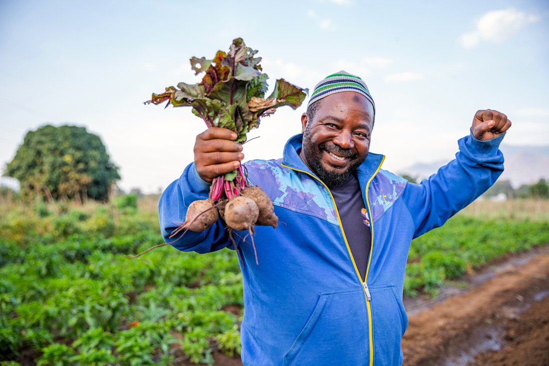 A man holds freshly picked beets