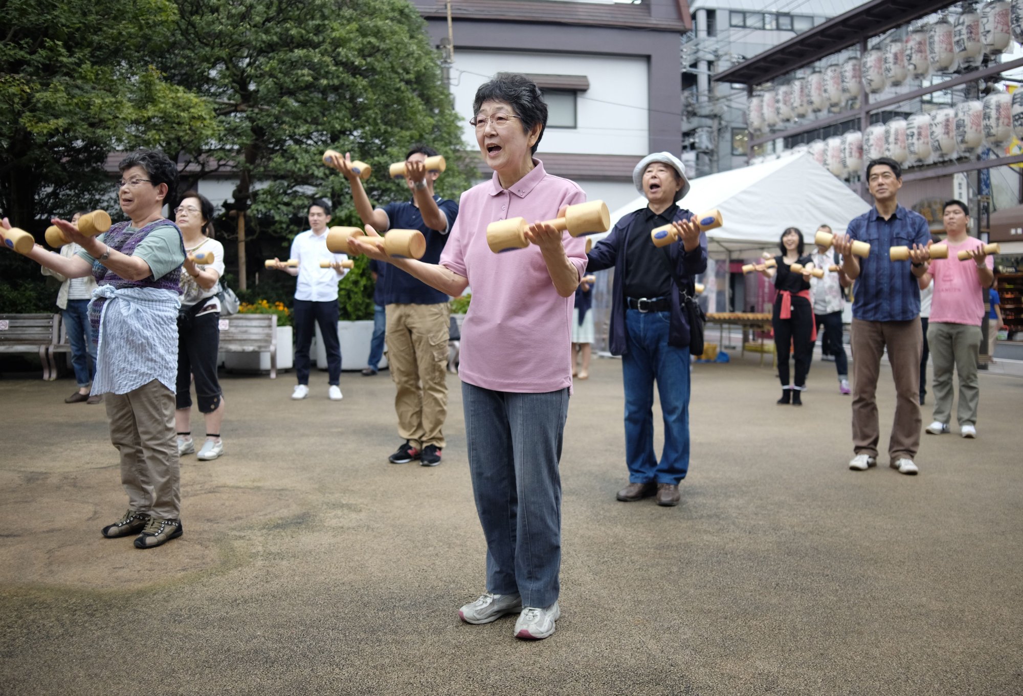 Elderly people work out with wooden dumb-bells in the grounds of a temple in Tokyo. 