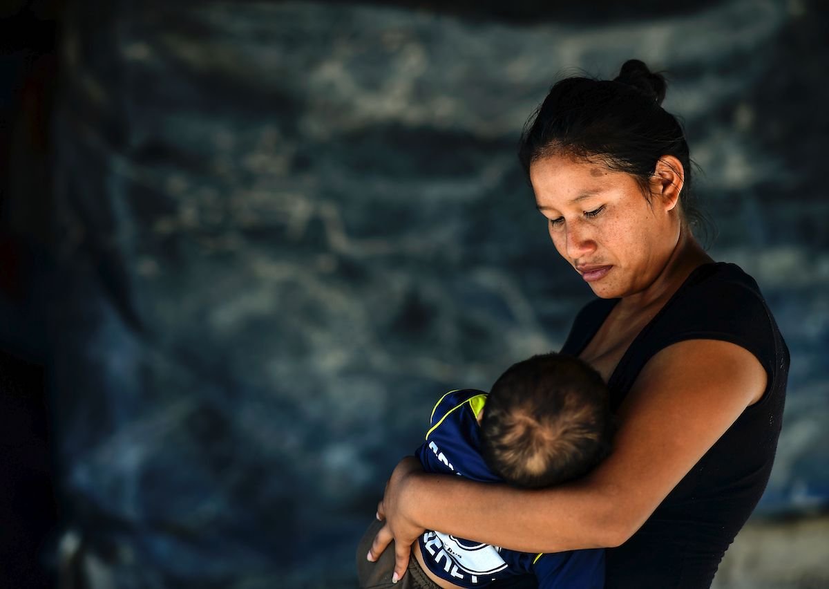 An indigenous Wichi woman breastfeeds her son in northern Argentina where inadequate access to safe drinking water and nutritious food has contributed to child mortality. | RONALDO SCHEMIDT/AFP via Getty Images