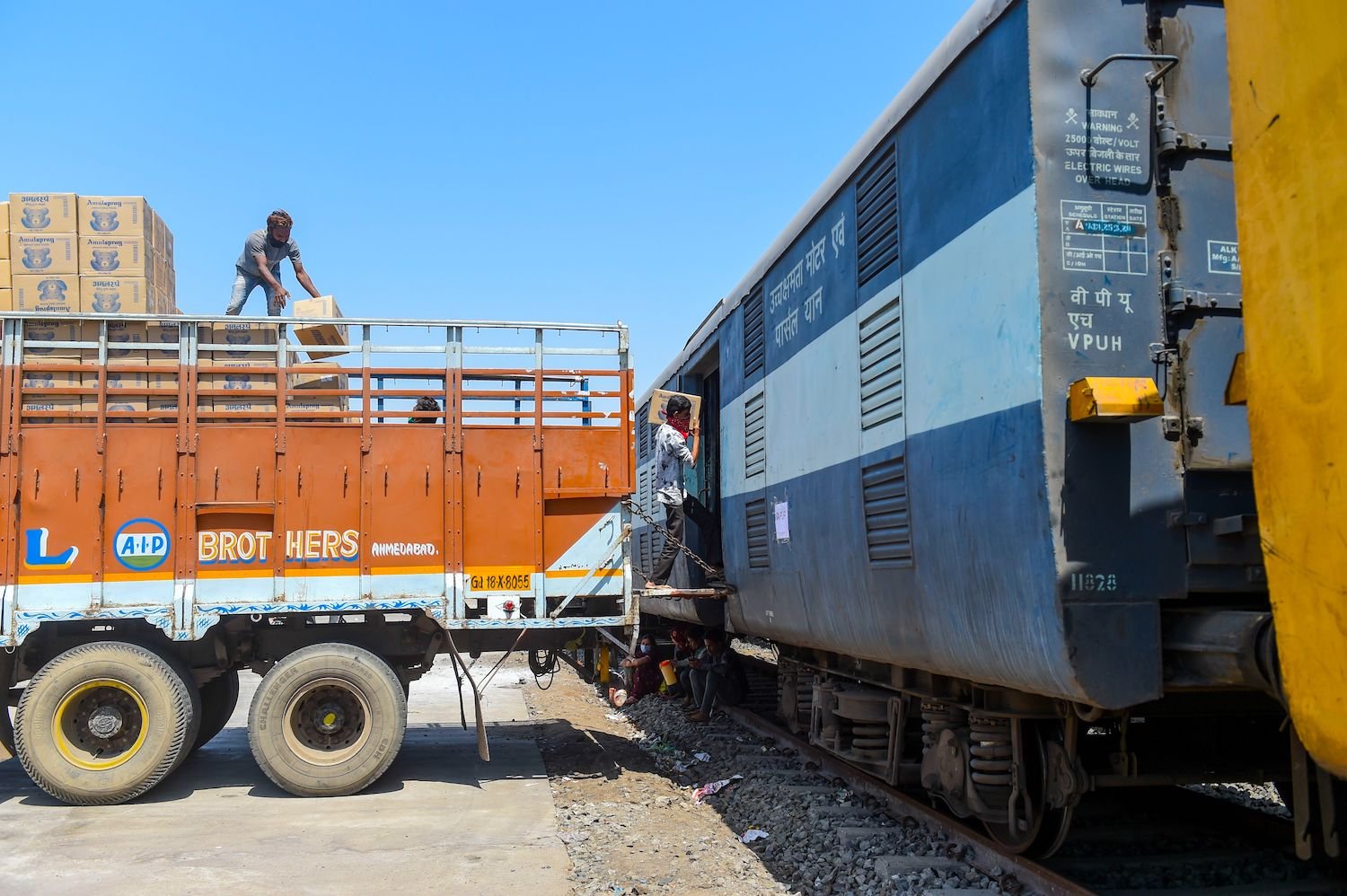 Workers load cartons of milk powder and baby food on a train in Ahmedabad during a nationwide COVID-19 coronavirus lockdown on March 31, 2020. | SAM PANTHAKY/AFP via Getty Images