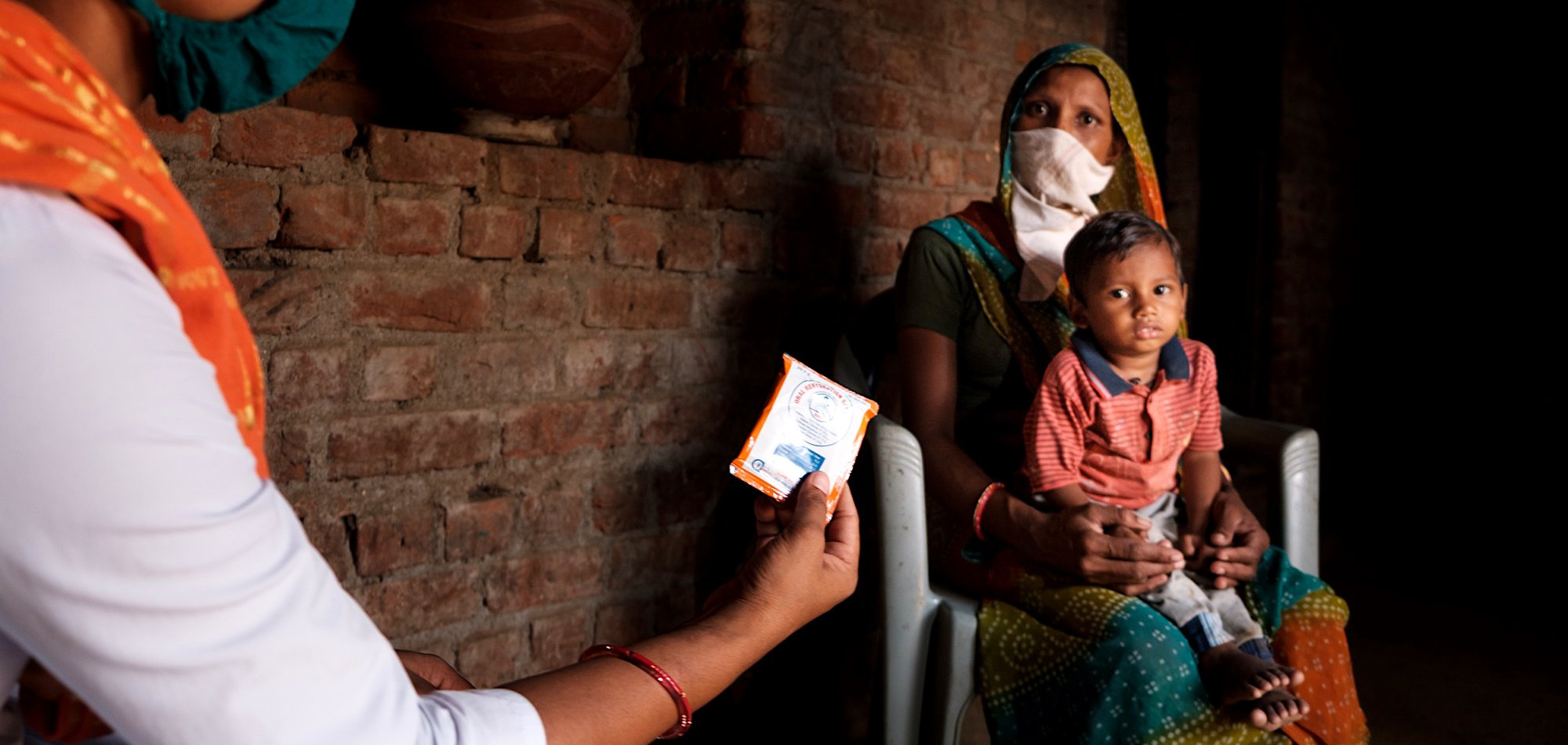 A mother and child receive vitamins during the Covid-19 lockdown. | Vinay Panjwani / UNICEF