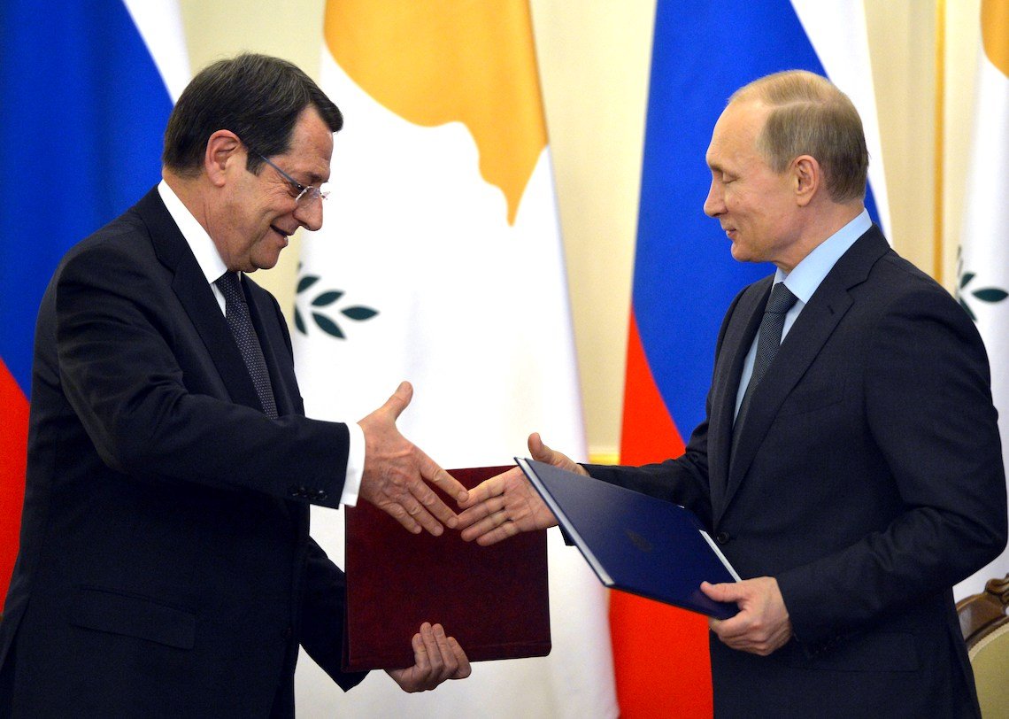 Cypriot President Nicos Anastasiades and Russian President Vladimir Putin exchange documents during a signing ceremony outside Moscow in February 2015. 