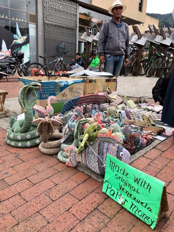 A Venezuelan refugee selling art made with bolivares—Venezuelan currency—in the streets of Bogotá, Colombia. (Photo: Moises Rendon, November 2019) 